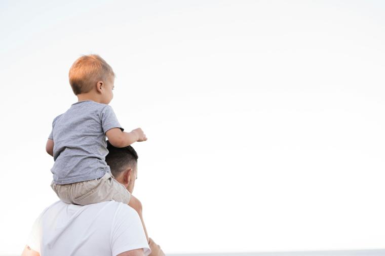 Boy sits on man's shoulders