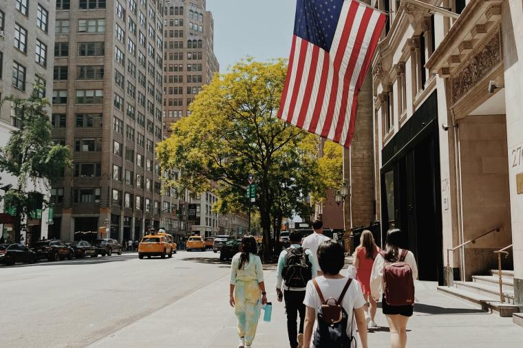 group of people walk down a city street